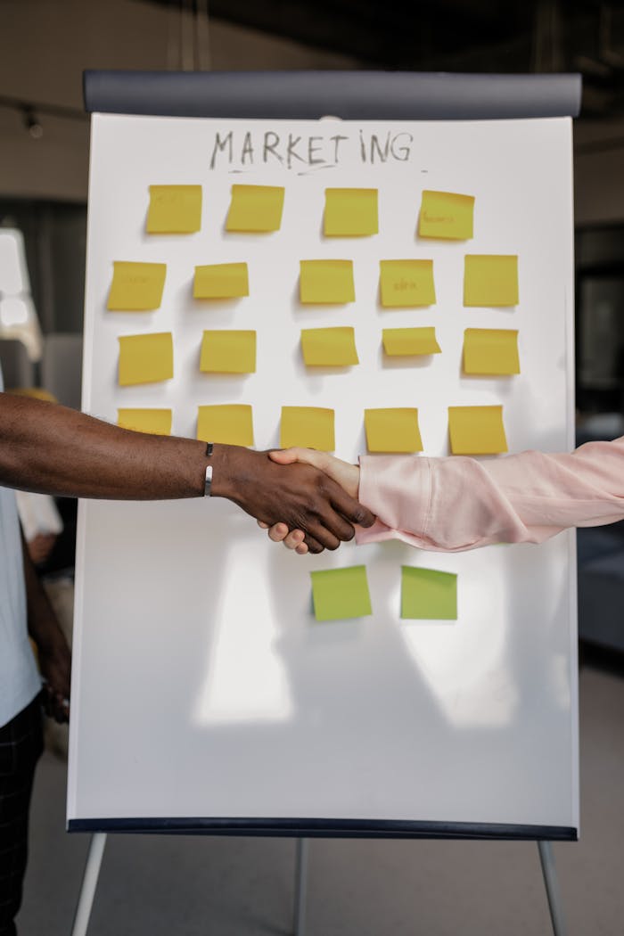 Mastering the First Impression: Your intriguing post title goes here Colleagues shaking hands in front of a marketing board during a business meeting.